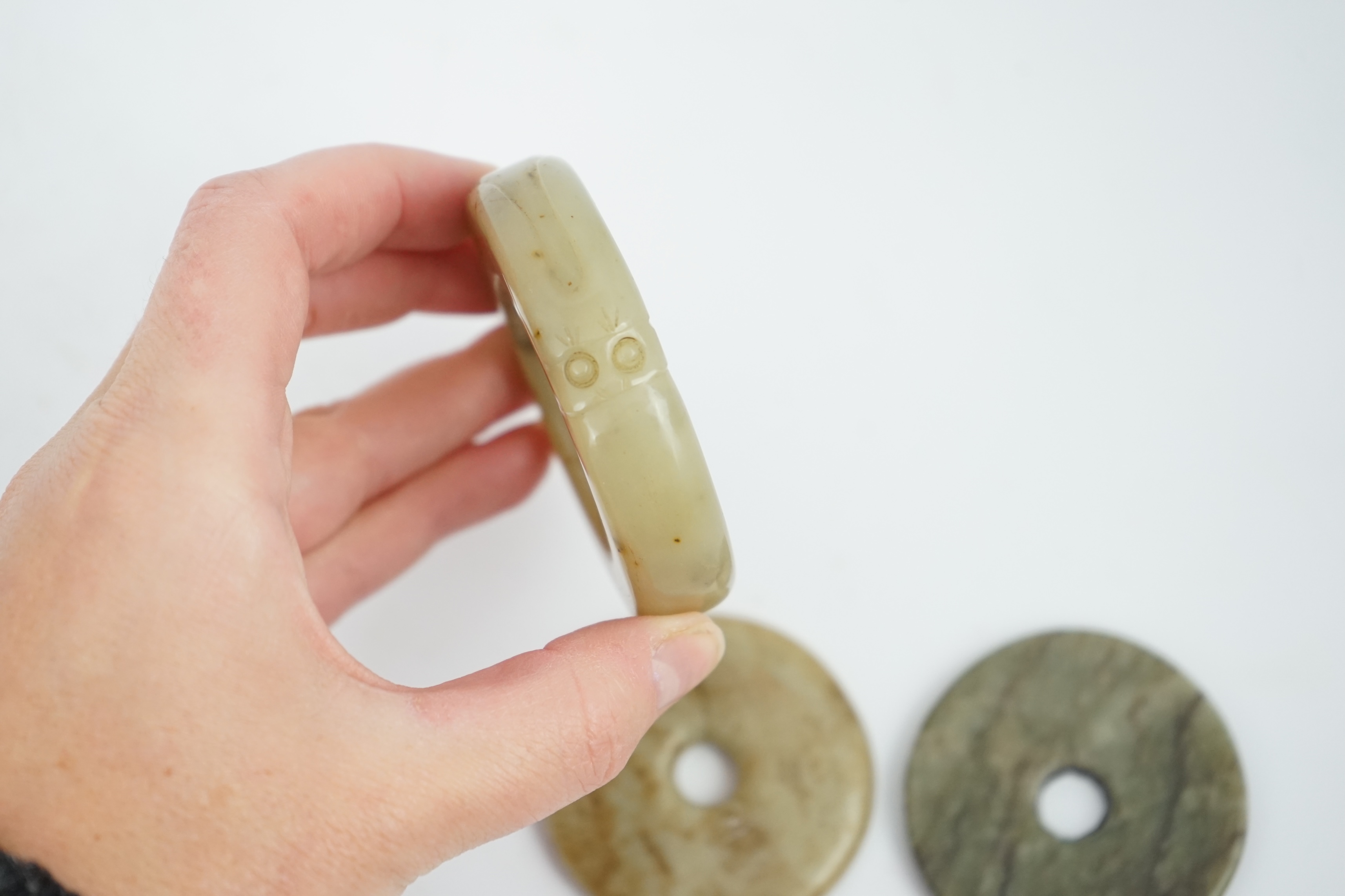 Two Chinese soapstone bi discs, and a jade ring, 18th century or earlier, largest 6.5cm in diameter. Condition - good